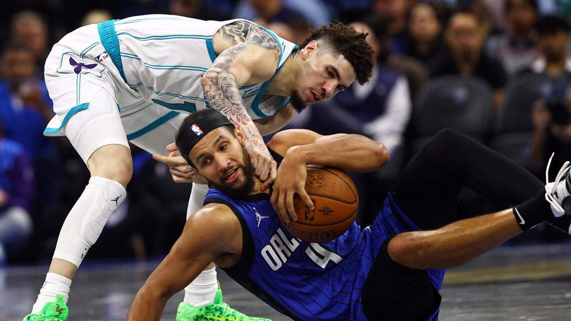 Charlotte Hornets guard LaMelo Ball (1) and Orlando Magic guard Jalen Suggs (4) go after the loose ball during the second half at Kia Center.