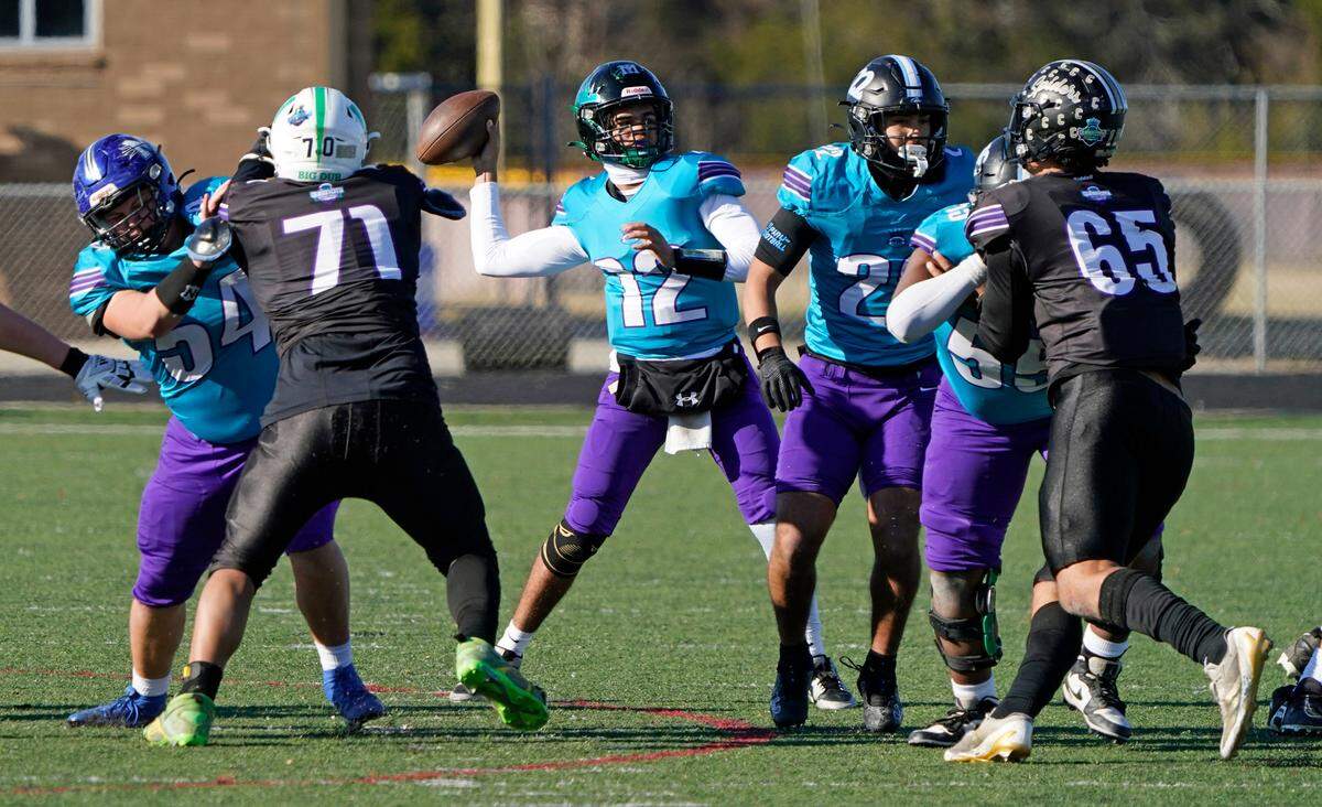 West quarterback Grayson Harvey, center, of Mountain Island Charter School winds up to pass during the second half in Saturday’s Queen City Senior Bowl high school football game at Olympic High School in Charlotte, N.C.. (CREDIT: Bill Kiser/Special to the Charlotte Observer)