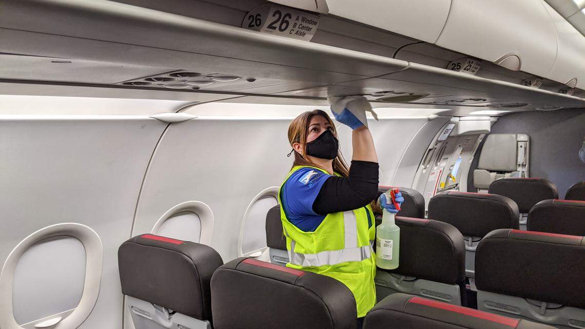 Jetstream Ground Services employee Lina Rodas Orozco cleans the inside of an American Airlines plane as the airline prepares for a spike in traffic out of hub Charlotte Douglas International Airport ahead of Thanksgiving.