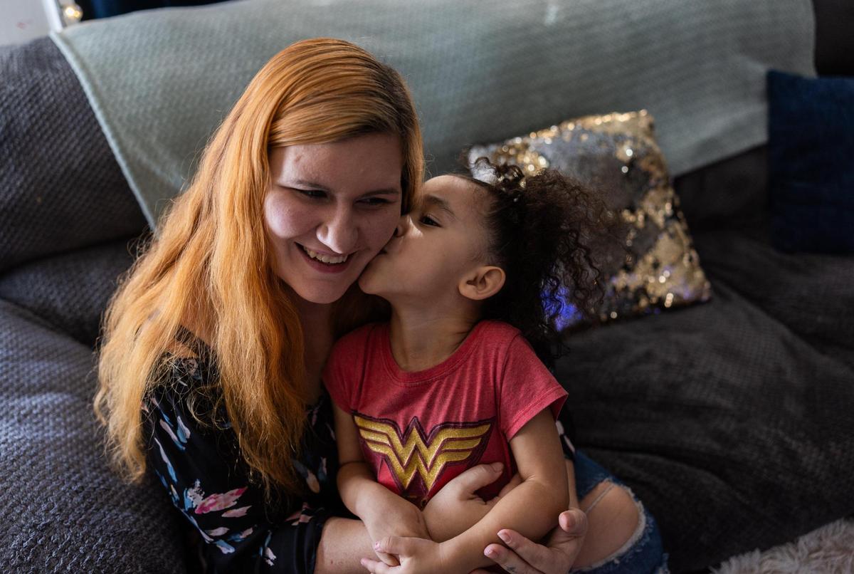 Heather Horne gets a kiss from her daughter, Aria, at their home in Charlotte last Friday.
