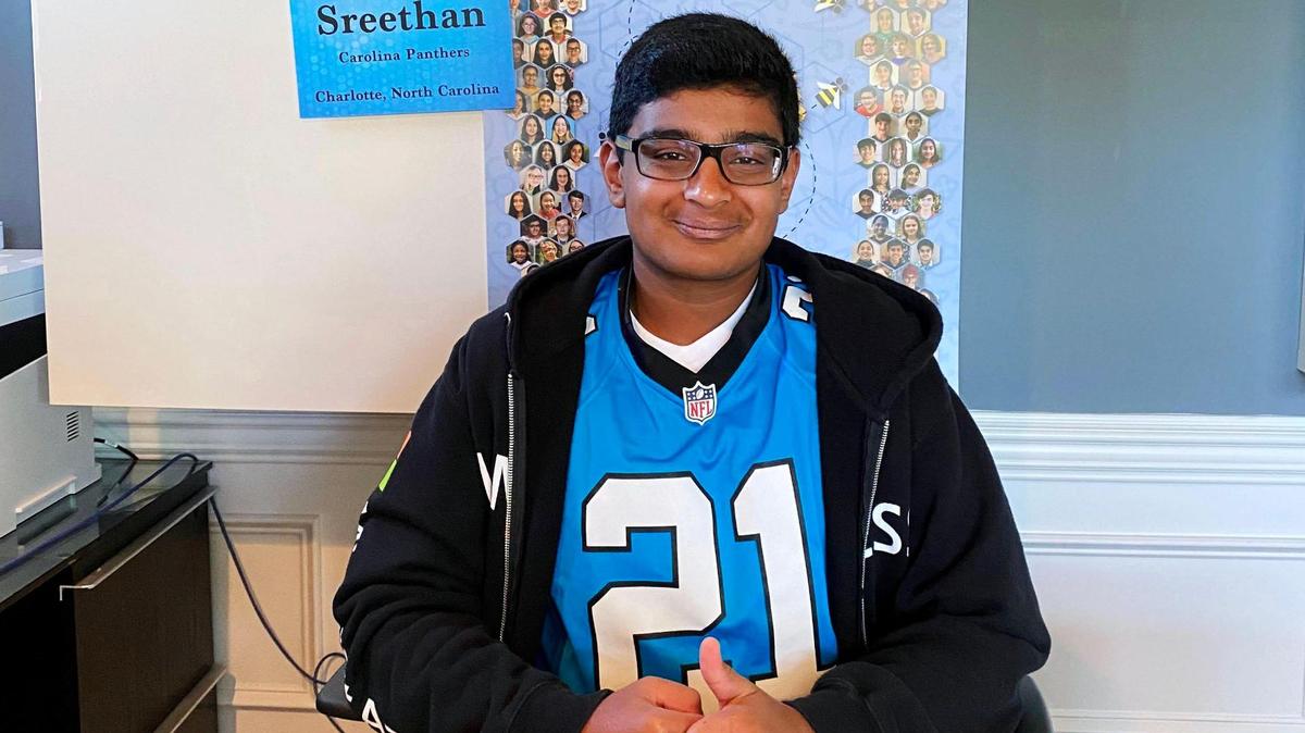 Sreethan Gajula sits at the desk from which he out-spelled all other North Carolina spellers, donning his lucky jacket as well as his jersey from his sponsors, the Carolina Panthers.
