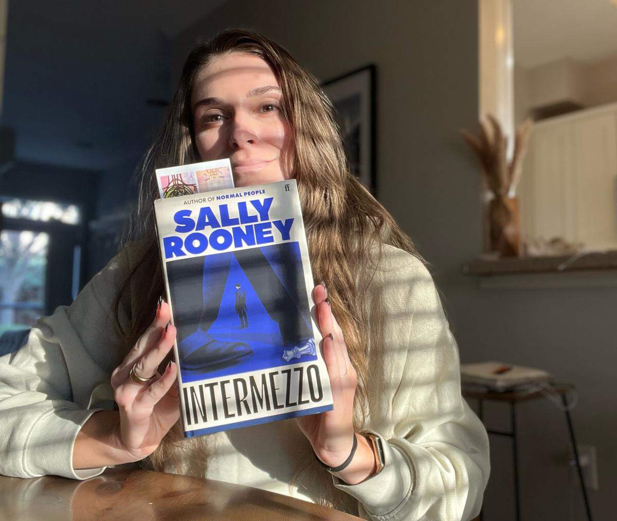 Sunny Hubler holds up a copy of “Intermezzo” by Sally Rooney.