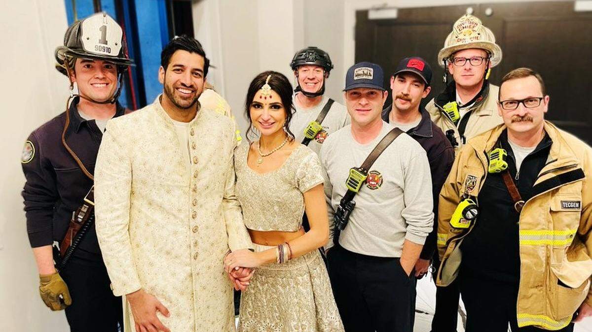 Members of the Charlotte Fire Department pose for a photo with a bride and groom after they were rescued from an elevator car inside the Bohemian Hotel early Sunday.