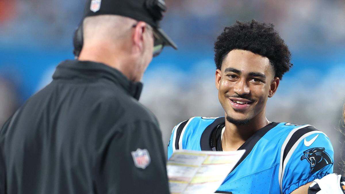 Carolina Panthers quarterback Bryce Young, right, smiles as he stands near head coach Frank Reich, left, during a break in second quarter action against the Detroit Lions on Friday, August 25, 2023 at Bank of America Stadium in Charlotte, NC.