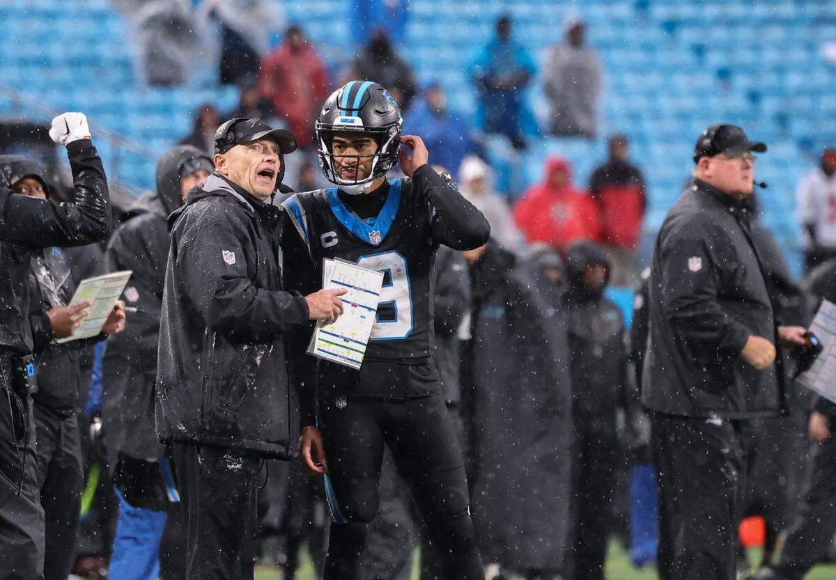 Carolina Panthers quarterback Bryce Young, right, talks to coach Chris Tabor at the Bank of America Stadium in Charlotte, N.C., on Sunday, December 17, 2023.