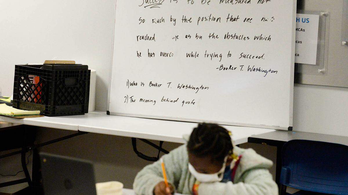 A quiz question is written on a lesson board as a student as a student works on his laptop while at the YMCA of Greater CharlotteÕs School Days+ remote learning program at the Stratford Richardson YMCA on Wednesday, February 3, 2021. Families from all different schools enroll their kids in the program, which is offered at multiple YMCA locations. The Y provides a safe and supportive space for students to do their individual remote learning.
