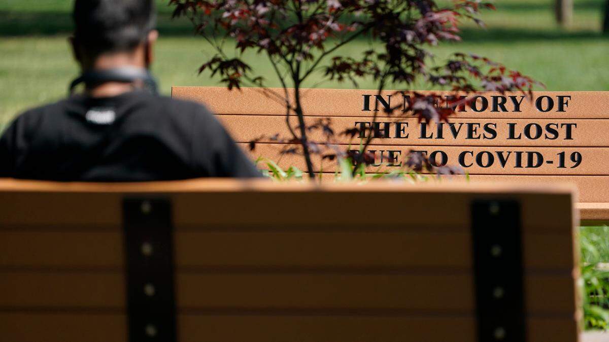 One thousand people have died of COVID-19 in Mecklenburg County, a grim milestone as COVID cases begin to spike locally again. The rest of the country also is recalling people who have died from COVID, including a man sitting near a bench memorializing people who died from COVID-19 in New Jersey.