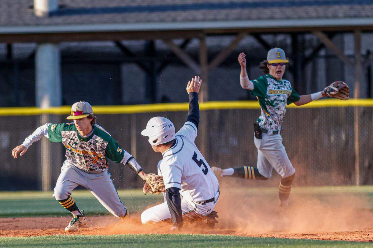 Independence ssecond baseman Cooper Golden, left, tags out Hough baserunner Scott Loubier as shortstop Jake Stanley, right, looks on in high school baseball action in Cornelius, N.C., Tuesday, April 19, 2022.