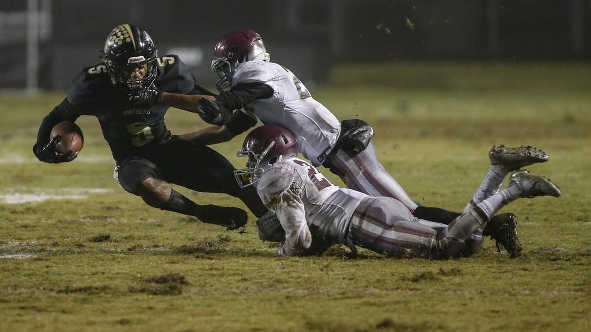 Providence wide receiver Caleb Ogunmola, left, is tackled by West Mecklenburg linebacker Louis Hawthorne and cornerback Keonte Cherry Friday night in SoMeck 4A football. Providence won 48-8.