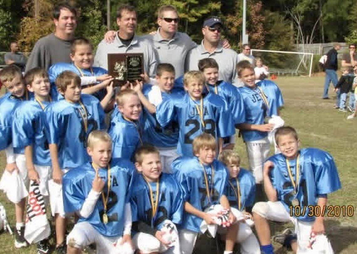 At age 8, Drake Maye (No. 21, kneeling on far right) already was one of the best players in the JEFA league in Huntersville, N.C. His father Mark (top left), a former starting quarterback at UNC, coached him and his three older brothers for many years in youth football.