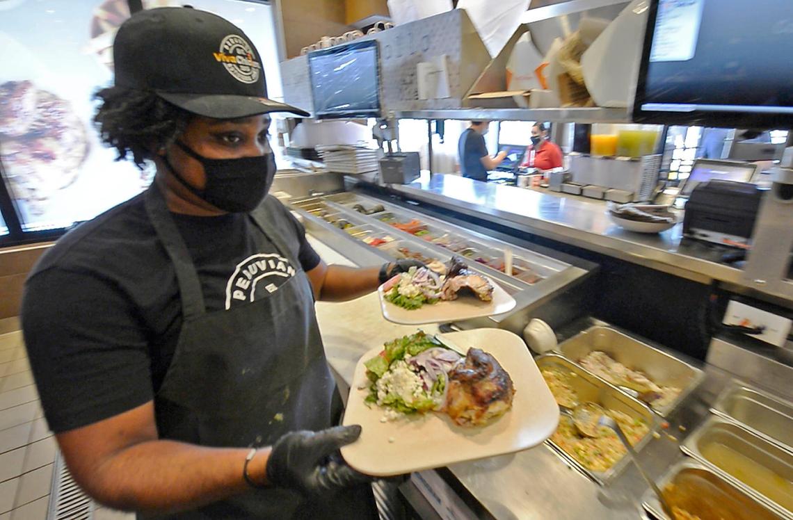 Amber Irby fills an order at Viva Chicken Waverly on May 14. The fast-casual Peruvian rotisserie chain has added a hiring bonus to to appeal to more applicants amid a nationwide worker shortage.  