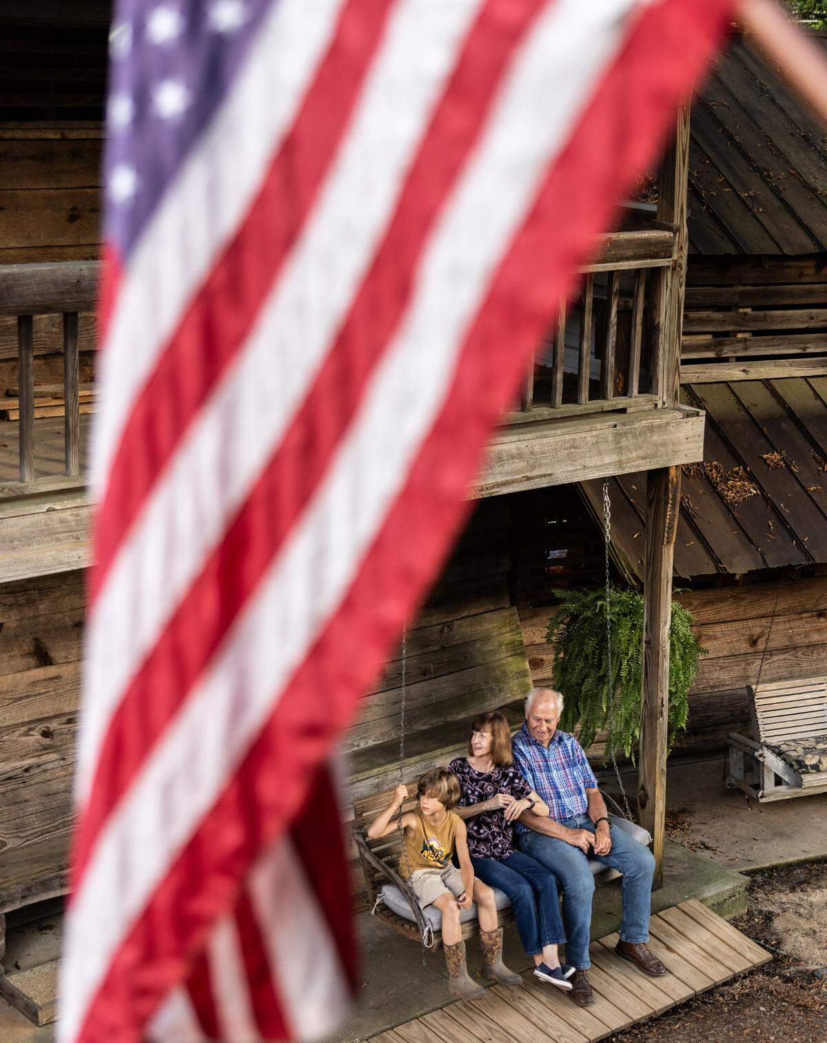 A family sits on the porch of their tent at Rock Springs Camp Meeting in Denver, N.C. For more than 200 years, families have gathered there to worship. These days, it’s a destination where they come from near and far, evolving from a bygone era but the event ​has since evolved from a place​ where settlers in covered wagons sought religious revival