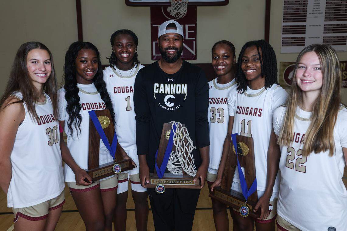 Cannon School’s girls basketball team and their head coach, Kelvin Drakeford, pose with their three NCISAA championship trophies on Wednesday, November 4, 2025.