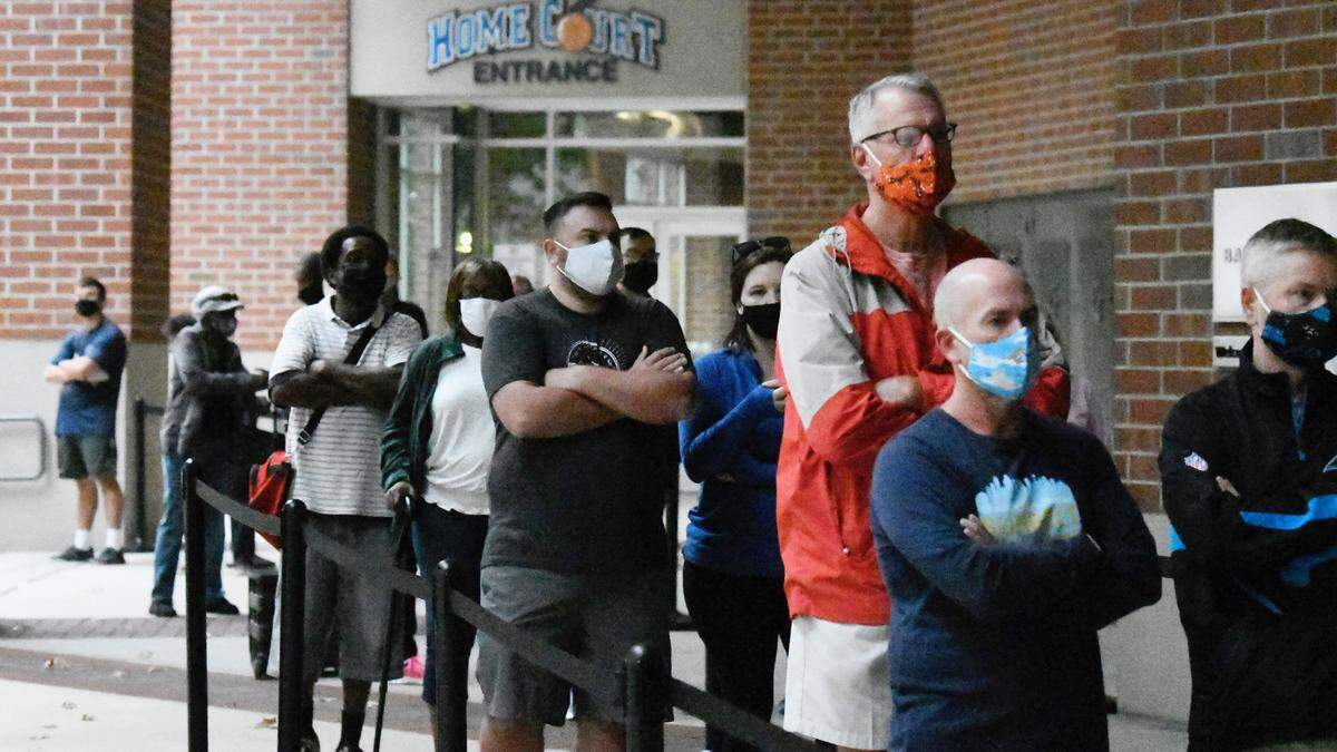 Voters line up in advance of polls opening at the Spectrum Center in Charlotte, N.C. for the first day of early voting Thursday, Oct. 15, 2020.