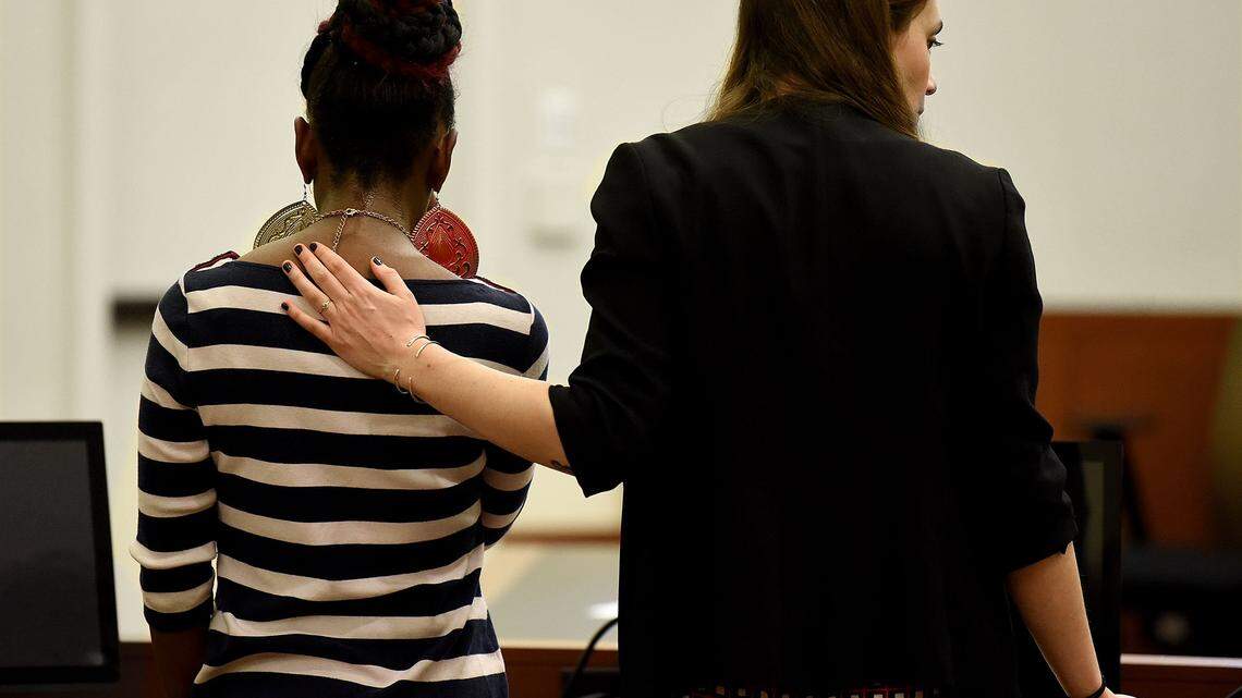 A lawyer shows support for a client during case hearings at the Mecklenburg County Courthouse for families with truant children who are missing school.  Families of kids who continually miss school at CMS can wind up in front of a judge. Several of those cases were heard on Thursday, March 29, 2018, in Courtroom 4330 before District Judge Paige McThenia.