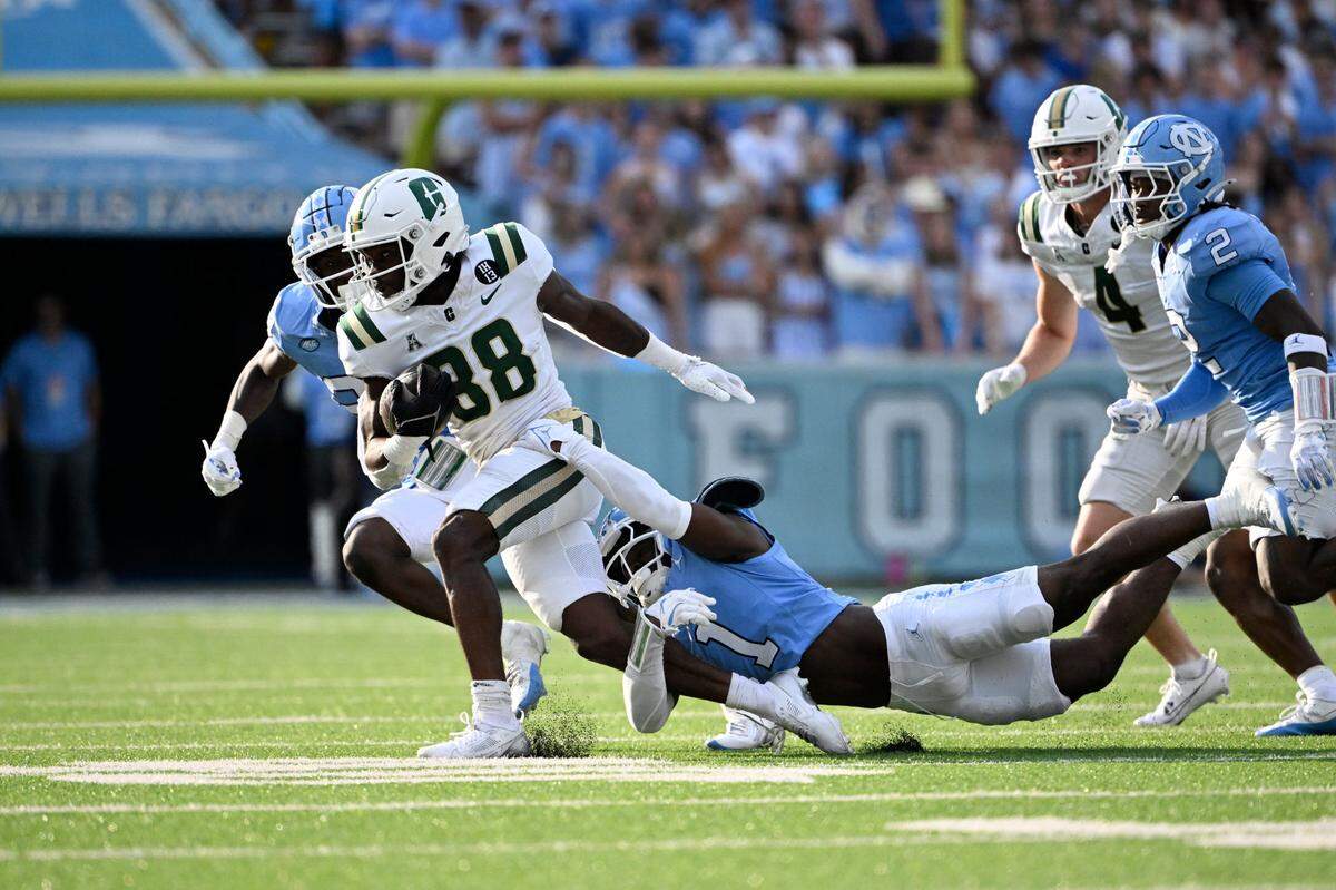 Charlotte 49ers running back Hahsaun Wilson (38) with the ball as North Carolina Tar Heels defensive back Antavious Lane (1) defends in the third quarter at Kenan Stadium. / Bob Donnan-Imagn Images
