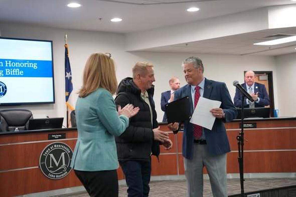 Greg Biffle was honored by the town of Mooresville in February 2025 for his achievements on and off the track. Congratulating Biffle are former town commissioner Lisa Qualls and Mayor Chris Carney.