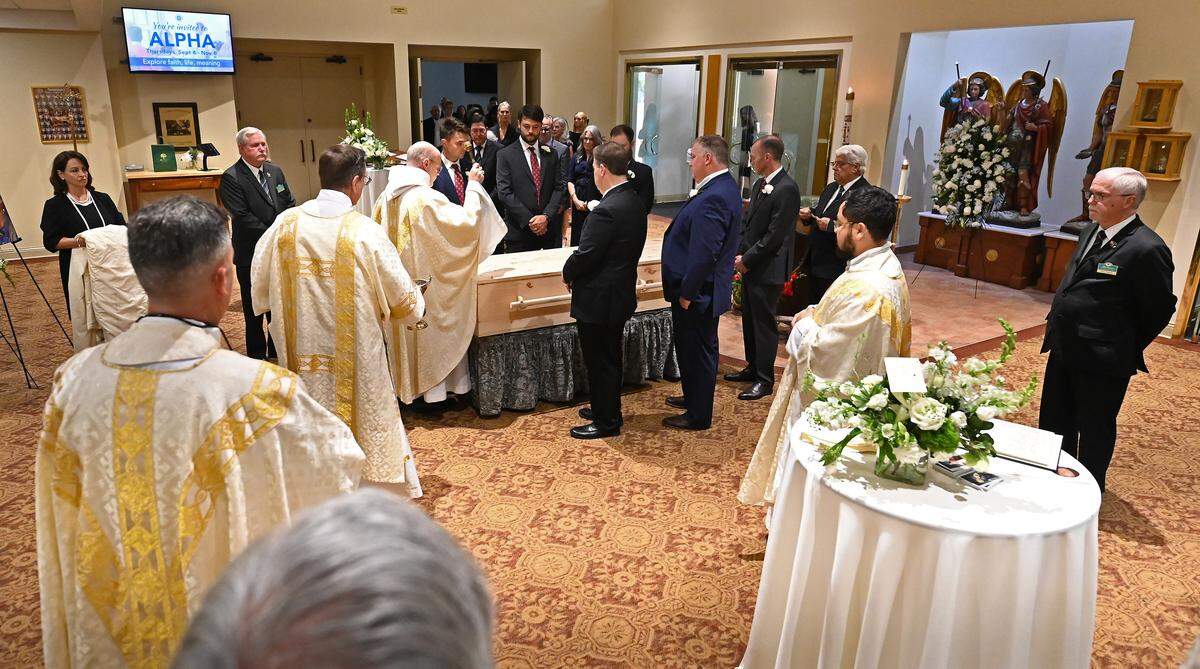 Abbot Placid Solari, a Benedictine monk, sprinkles Holy Water on the casket of former longtime Charlotte Motor Speedway president H.A. “Humpy” Wheeler, Jr., on Tuesday, August 26, 2025 at St. Gabriel Catholic Church in Charlotte. Abbot Solari is Abbot of Belmont Abbey and Chancellor of Belmont Abbey College.