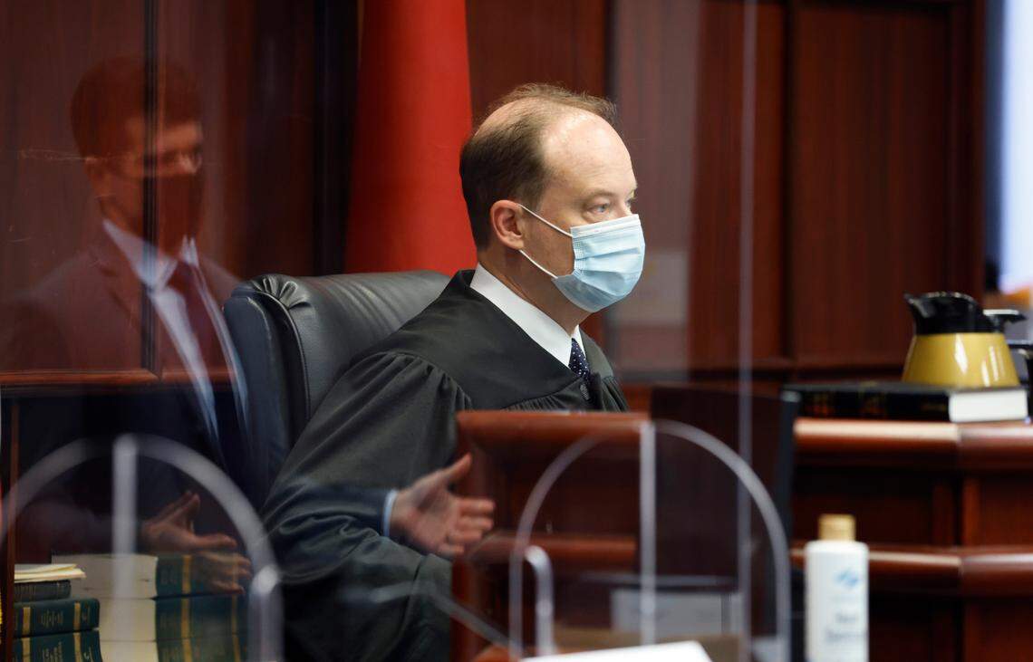 Judge Martin McGee listens to attorney Christian Ferlan, reflected at left, at the Wake County Courthouse in Raleigh, N.C., Thursday, October 21, 2021. McGee is part of a three judge panel who listened to arguments Thursday about the constitutionality of temporarily suspending the statute of limitations for child sex abuse lawsuits.