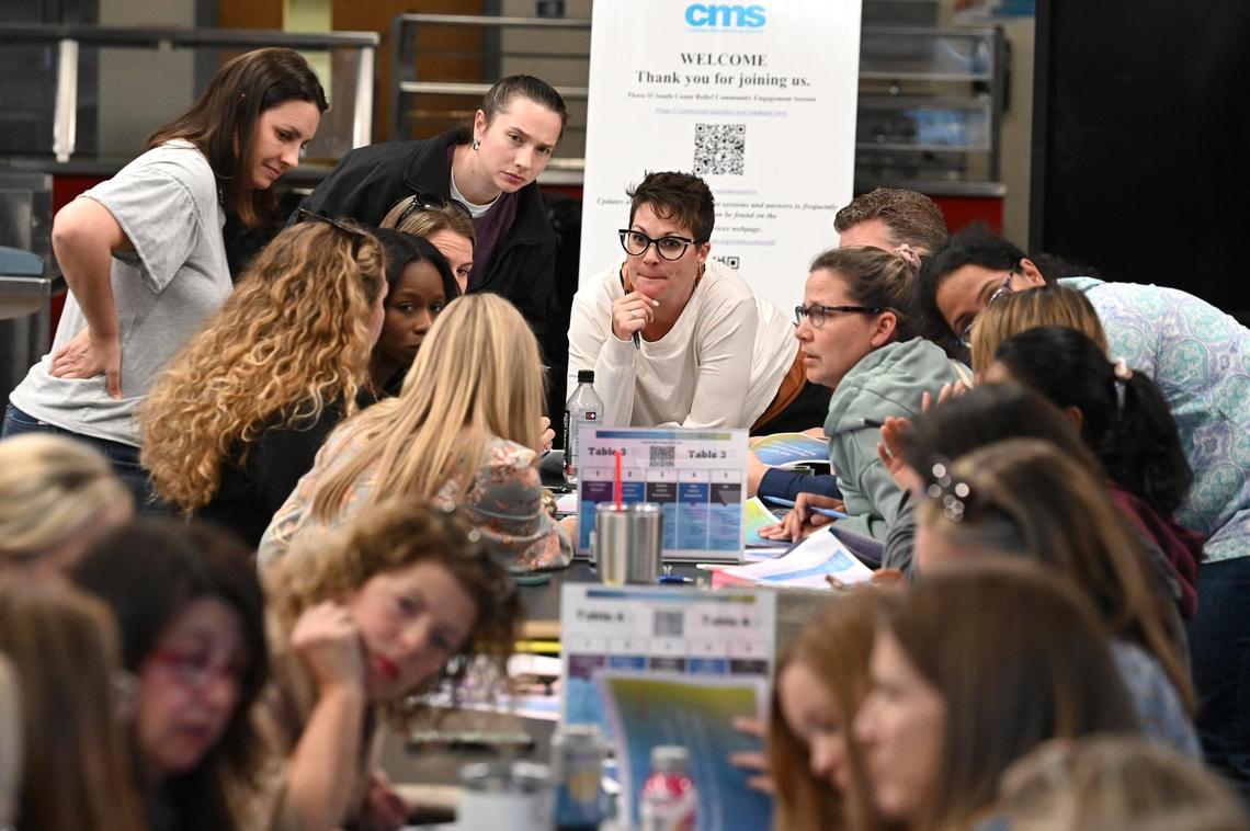 Parents gather in a work group during a meeting at South Meck High to learn about the new boundaries CMS is proposing on Wednesday, March 29, 2023.