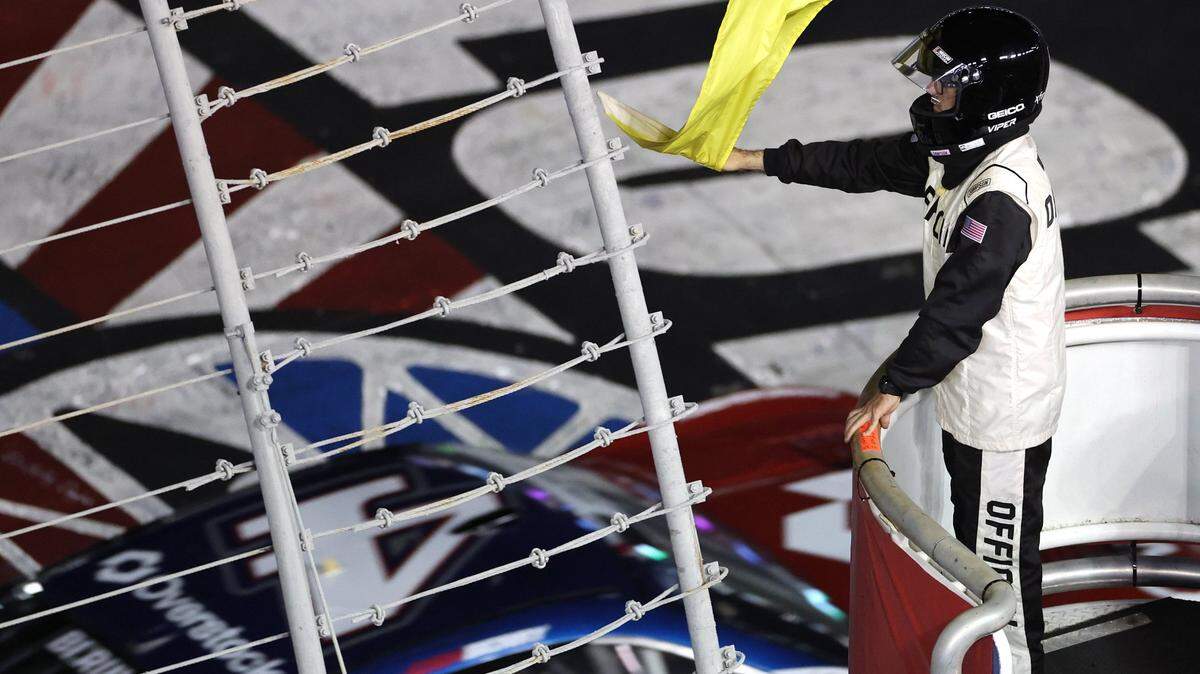A NASCAR official waves the yellow flag to signal the field in Sunday’s Coca-Cola 600 that the race is under caution due to severe weather in the area of Charlotte Motor Speedway. The red flag was later waved stopping the race.