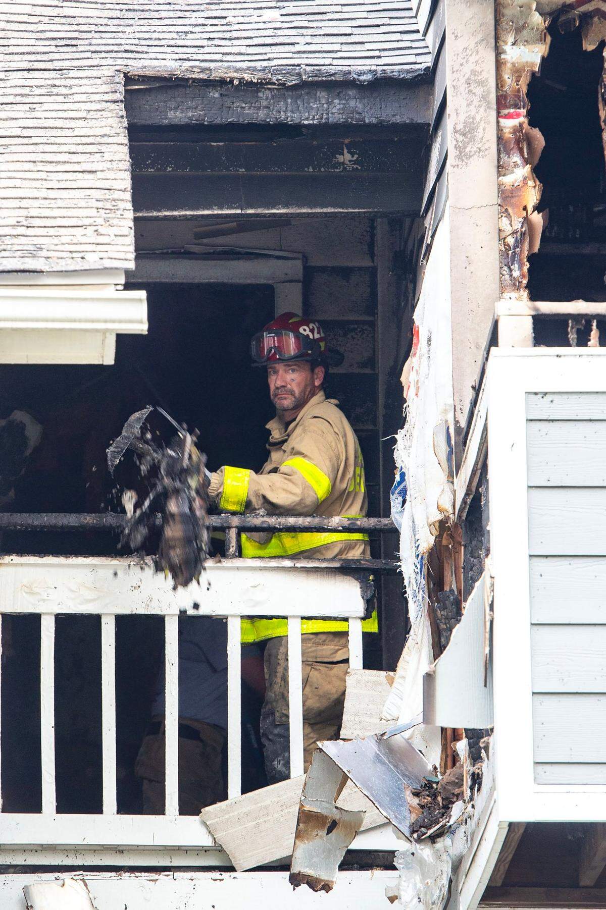 A Charlotte department firefighter shovels debris out of the damaged unit at Aurea Station Apartments in Charlotte Thursday, July 10, 2025.