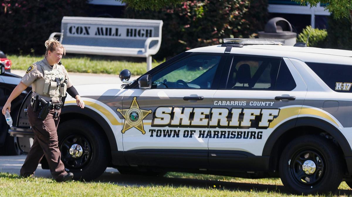 A Cabarrus County sheriff’s deputy walks to her vehicle following a bomb threat at Cox Mill High School in Concord, N.C., Tuesday, Sept. 20, 2022.