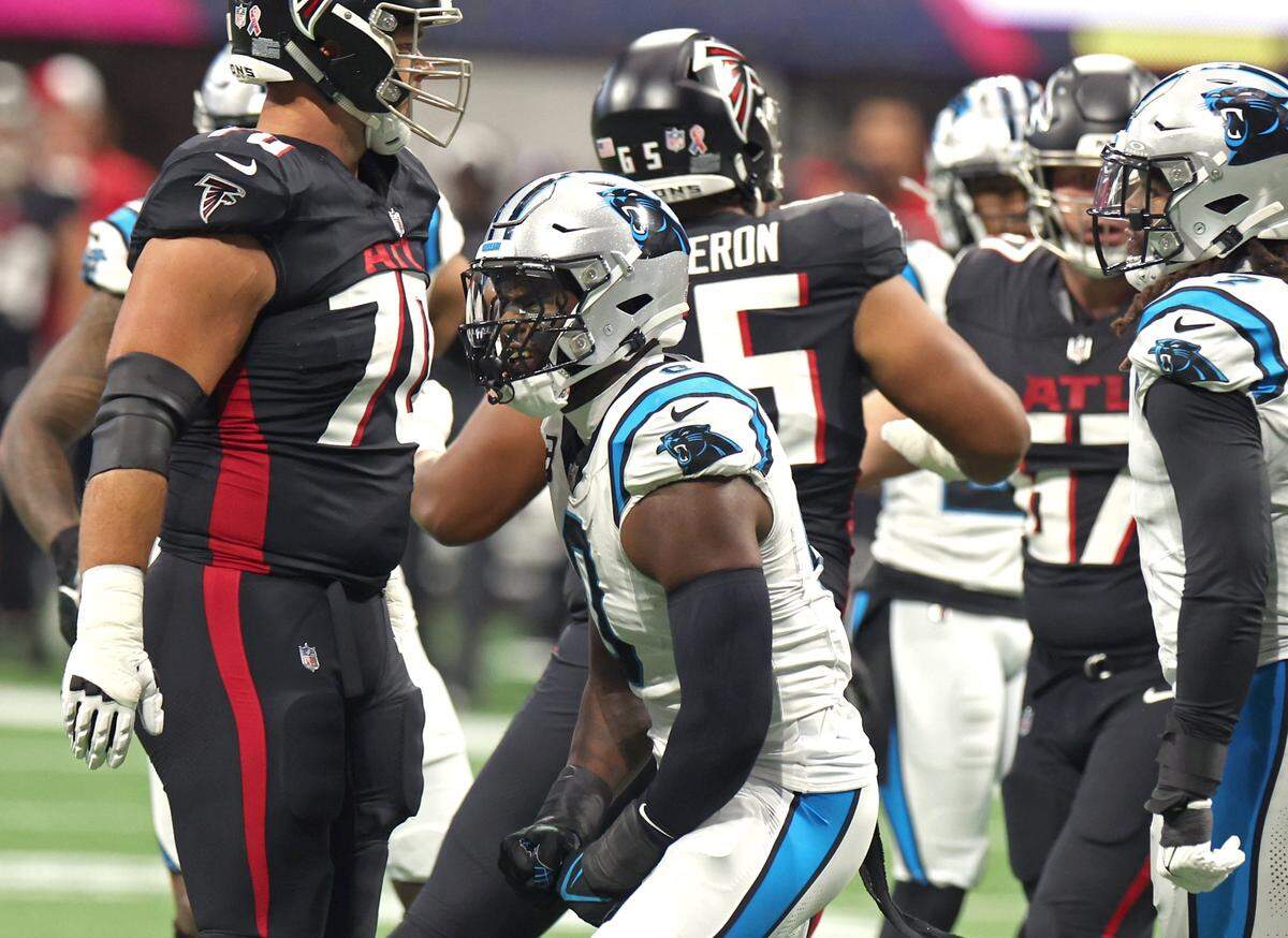 Carolina Panthers linebacker Brian Burns, center, celebrates his strip of the ball from Atlanta Falcons quarterback Desmond Ridder of the ball during first-quarter action at Mercedes-Benz Stadium in Atlanta, GA on Sunday, September 10, 2023.