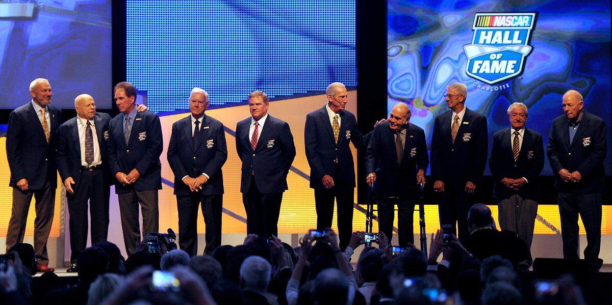 NASCAR Hall of Fame members (L-R) Dale Jarrett, Bruton Smith, Darrell Waltrip, Junior Johnson, Terry Labonte, Ned Jarrett, Jerry Cook, Leonard Wood, Rex White and Jack Ingram pose on the stage following the NASCAR Hall of Fame Induction Ceremony on Saturday, January 23, 2016. 