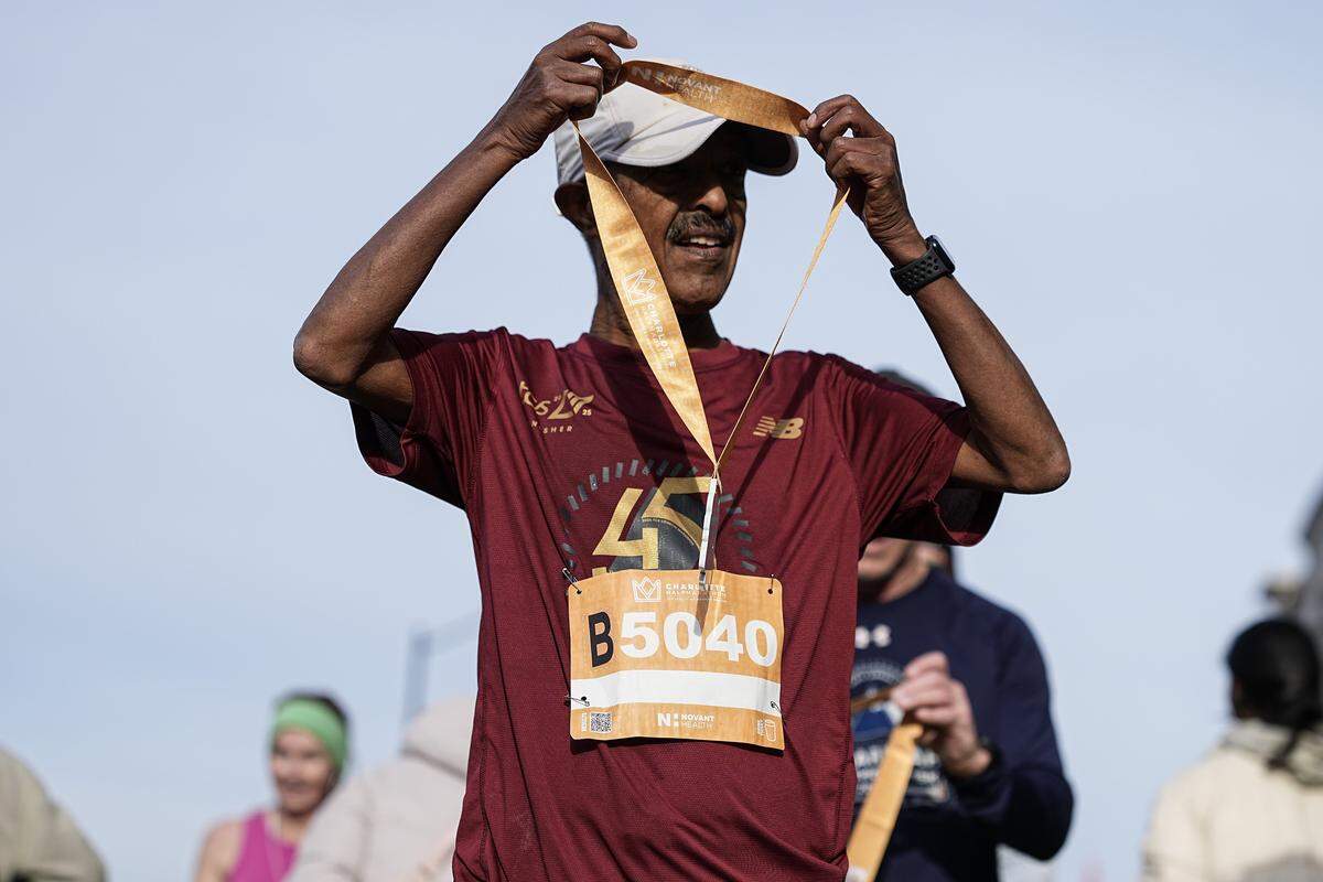 A participant receives their medal after competing in the Novant Health Charlotte Marathon Saturday, Nov. 15, 2025, in Charlotte, N.C.