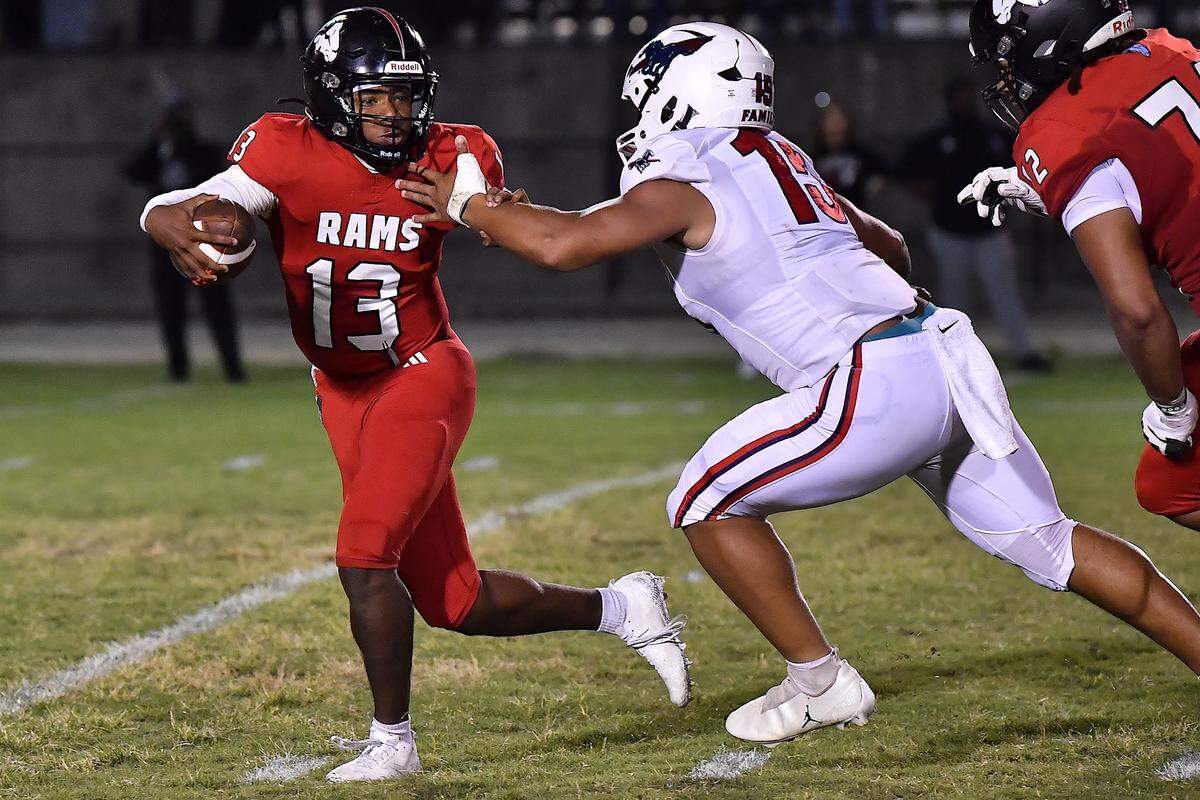 Rolesville quarterback Kaleb Williams (13) is pressured by Providence day defensive lineman Jace Goodwin (15) during the first half. The Rolesville Rams and the Providence Day Chargers met in a non-conference football game in Rolesville, N.C. on August 29, 2025.