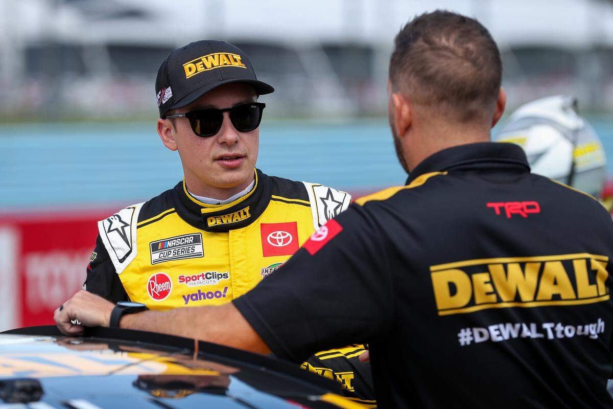 Aug 19, 2023; Watkins Glen, New York, USA; NASCAR Cup Series driver Christopher Bell (left) talks with a crew member during practice and qualifying for the Go Bowling at The Glen at Watkins Glen International.