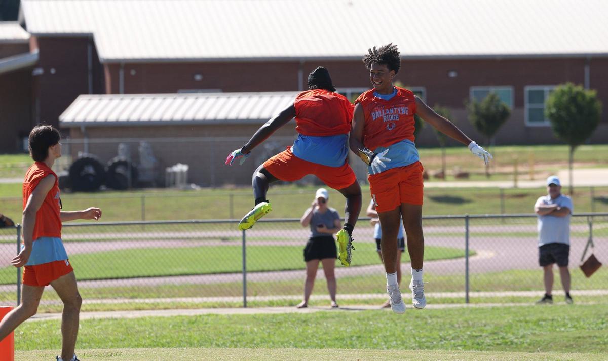 Players on offense celebrate a touchdown during a scrimmage as they tryout for Ballantyne Ridge, a new high school opening this year in south Charlotte, on Thursday, July 11, 2024. The team’s first game will be this Friday, August 23rd against Fort Mill.