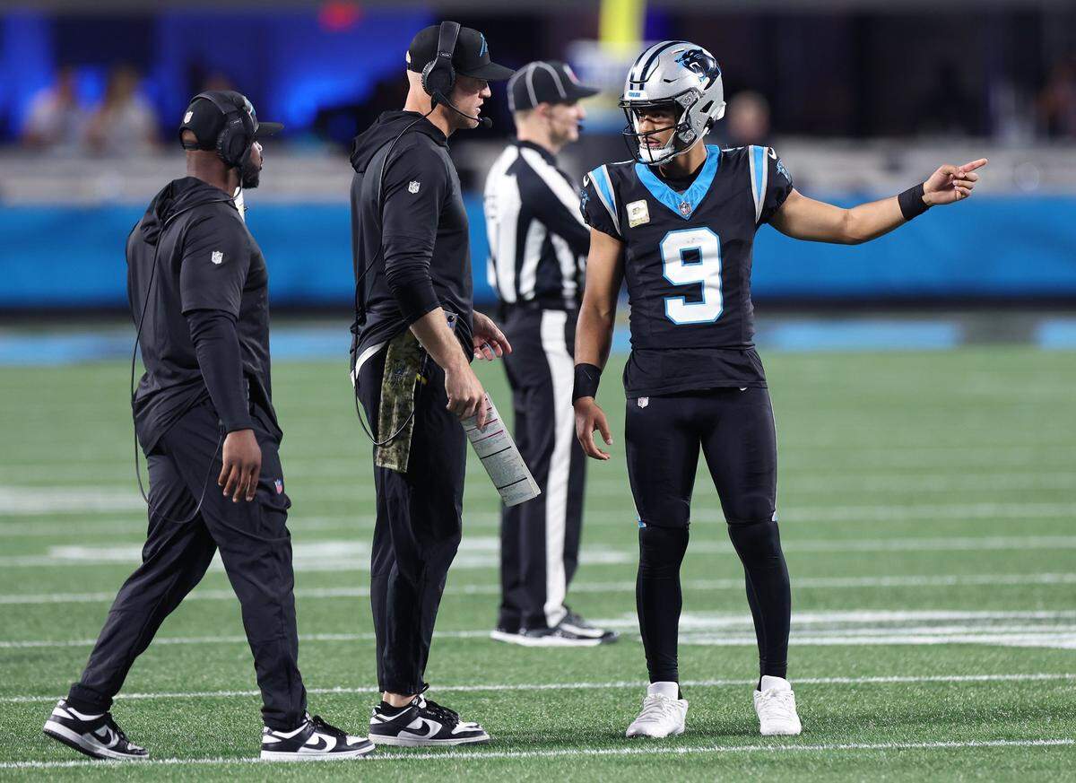 Carolina Panthers offensive coordinator Thomas Brown, left, walks up as quarterbacks coach Josh McCown, center, speaks with quarterback Bryce Young, right, during fourth-quarter action against the Indianapolis Colts on Sunday, November 5, 2023 at Bank of America Stadium in Charlotte, NC. The Colts defeated the Panthers 27-13.