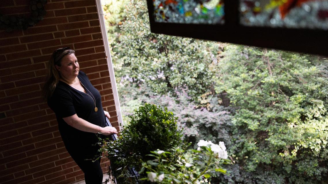 Jennifer Jackson, shown here standing on the balcony of her condo in Charlotte, says her HOA fined and billed her thousands of dollars for a drainage problem that she didn’t cause.