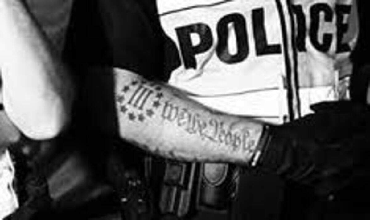 The tattoo in question has 12 stars encircling the Roman numeral three whereas the Three Percenter logo has 13.  Screenshot from Twitter.