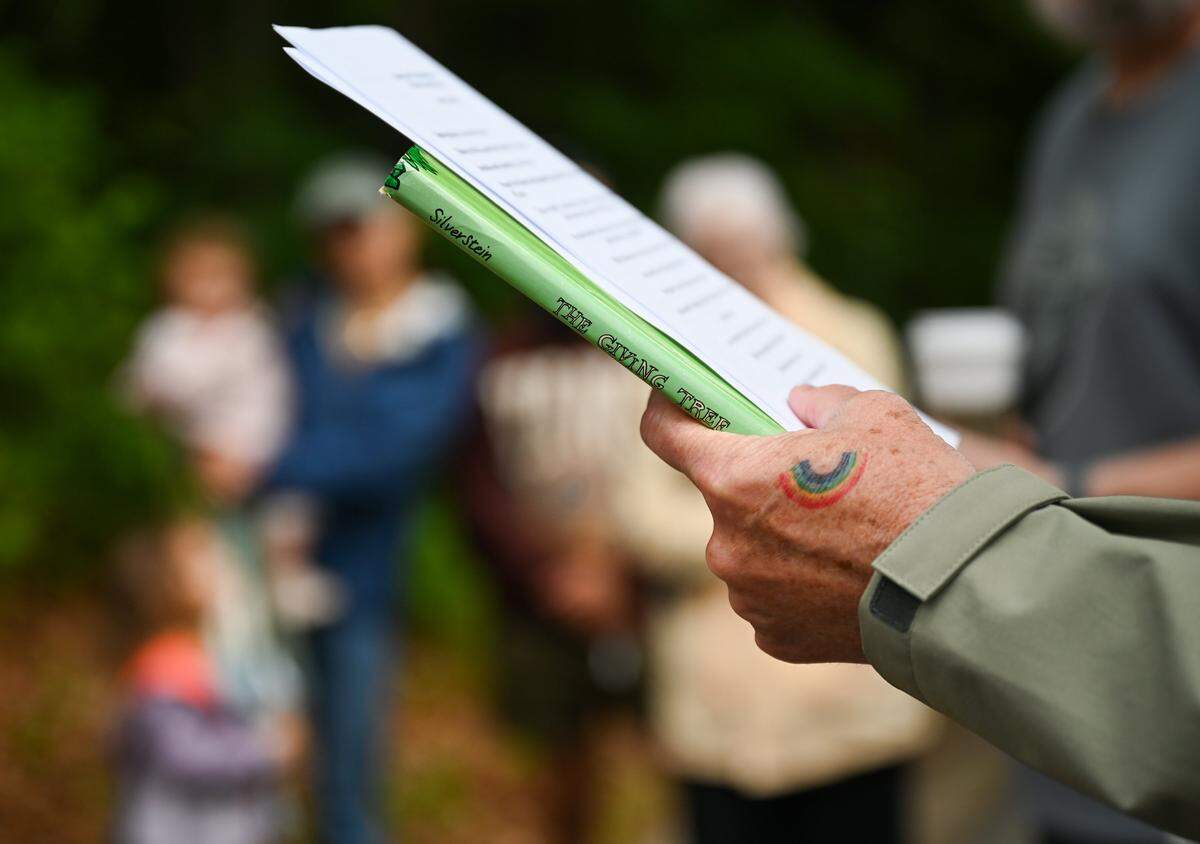 An alternative to Shel Silverstein's “The Giving Ttree”, in which the tree encourages the man in the story to look elsewhere for resources instead of taking from the tree, is read during a memorial service for a 6.6-acre wooded area that the city approved rezoning on for housing.