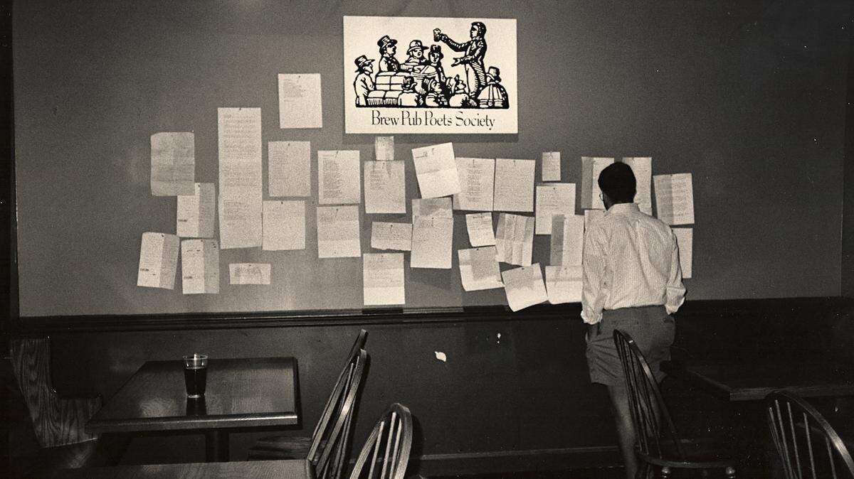 A patron at Dilworth Brewing Company looks over poems brought to the first Brew Pub Poets Society meeting in 1990.