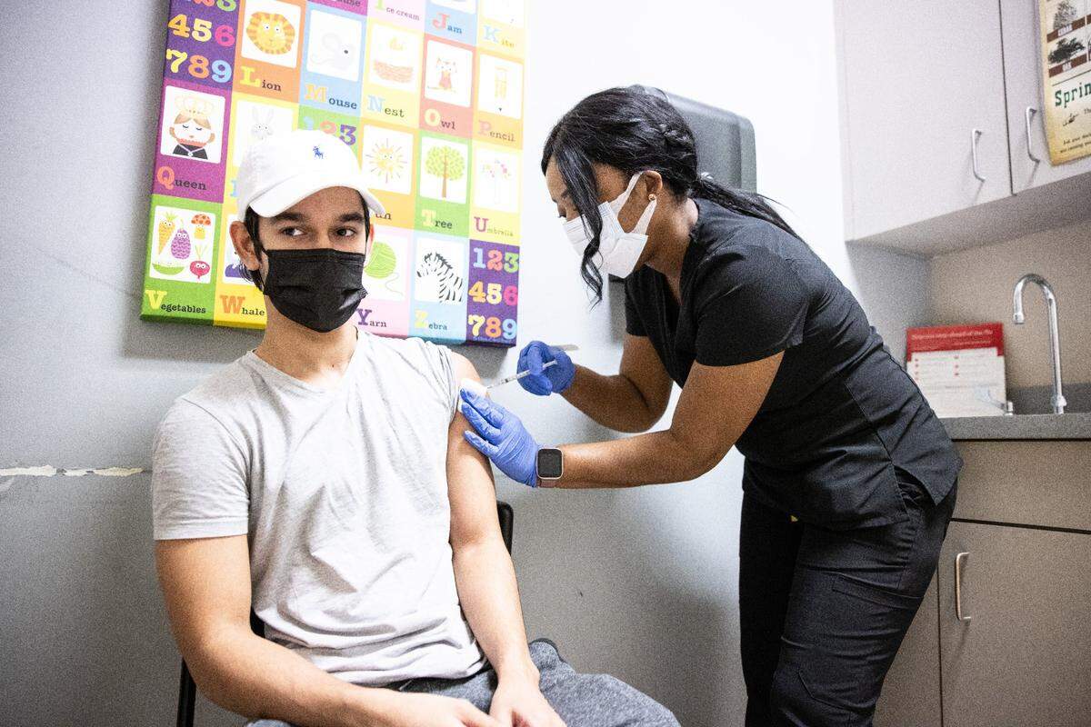 Quantina Oliver, right, gives Ibrahim Shroff a COVID-19 vaccine at Central Pediatrics and Internal Medicine, NC, on Wednesday, April 10, 2021. Companies are now debating whether to require their employees to get vaccinated, and politicians are split on the issue.