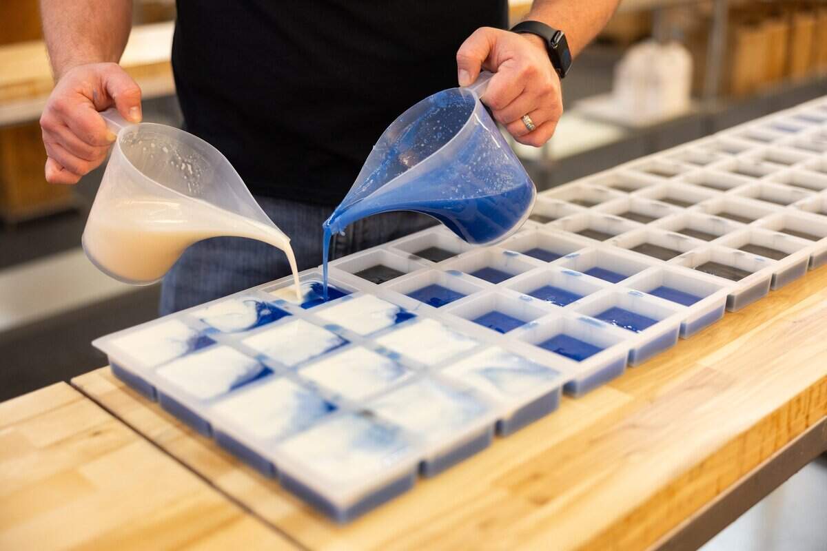 An employee pours soap at the warehouse for Sparta Candle Co.