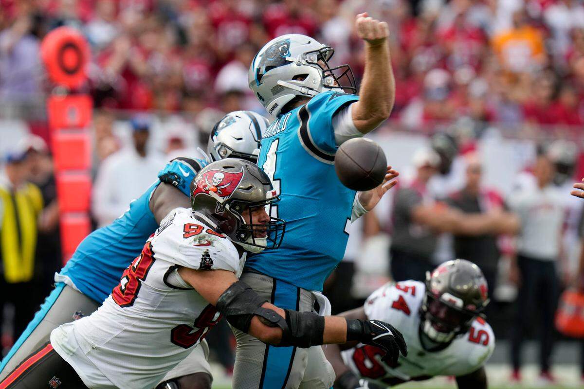 Carolina Panthers quarterback Sam Darnold is sacked by Tampa Bay Buccaneers linebacker Anthony Nelson forcing a fumble during the second half of an NFL football game between the Carolina Panthers and the Tampa Bay Buccaneers on Sunday, Jan. 1, 2023, in Tampa, Fla. (AP Photo/Chris O’Meara)