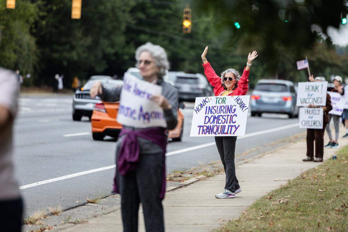 Residents of Southminster retirement community line the sidewalk of Park Road for a non-partisan patriotic march in Charlotte, N.C., on Wednesday, October 8, 2025.