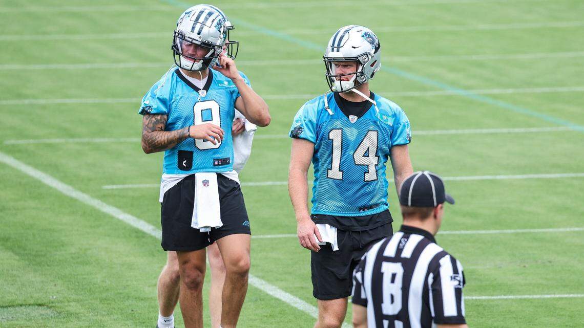 Panthers quarterbacks Matt Corral, left, and Sam Darnold, center, walk on to the practice field during day two of mini camp on Wednesday, June 15, 2022 in Charlotte, NC.