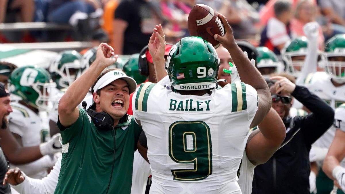 Charlotte coach Will Healy, left, celebrates with defensive tackle Joshua Bailey after Bailey recovered an Illinois fumble near the goal line last week in Champaign, Ill. The 49ers will play at Florida International on Friday night.