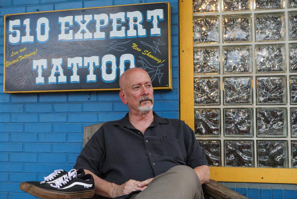 Mel McAdams sits outside 501 Expert Tattoo where his son, Logan McAdams, worked as an artist. His parents and friends say they’re angry the person who sold him fentanyl, which he overdosed and died from, is not being charged by police.