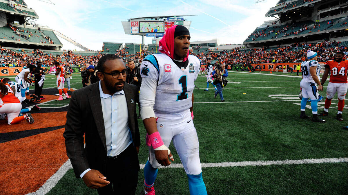 Carolina Panthers QB Cam Newton (1) walks off the field with Steven Drummond after a game in 2014.