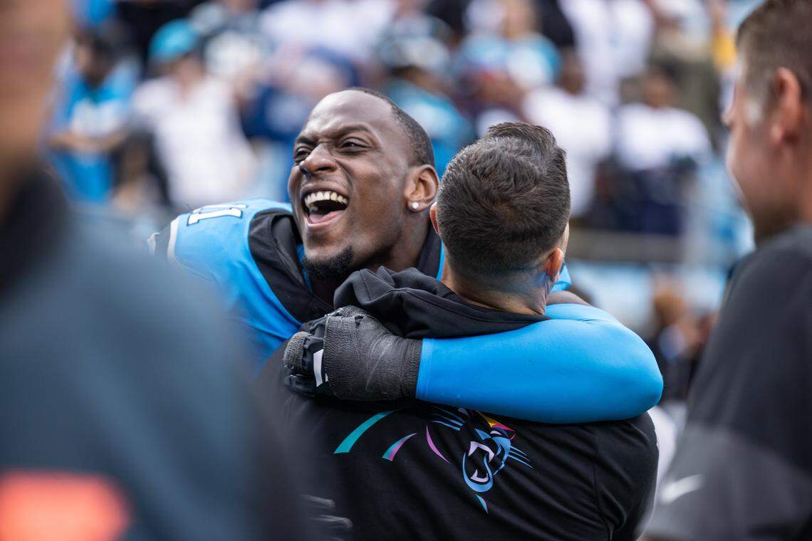 Carolina Panthers linebacker Nic Scourton gives coach Dave Canales a hug after winning their Oct. 12, 2025, game against the Dallas Cowboys at Bank of America Stadium.