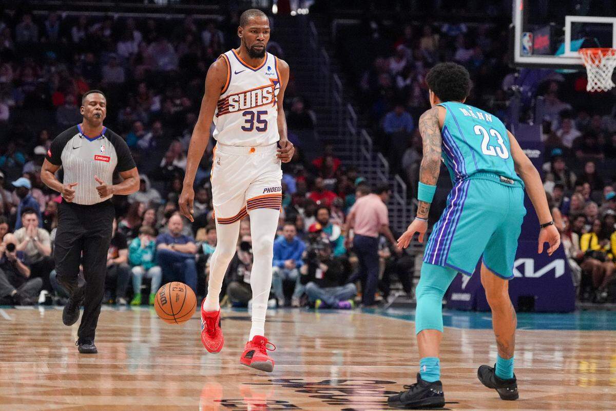 Mar 15, 2024; Charlotte, North Carolina, USA; Phoenix Suns forward Kevin Durant (35) brings the ball up court against Charlotte Hornets guard Tre Mann (23) during the first quarter at Spectrum Center.