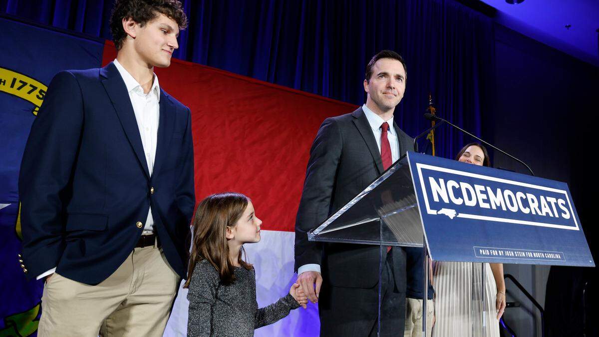 As his daughter Avery looks up at him and son Haden watches, Attorney General-elect Jeff Jackson addresses the crowd during a North Carolina Democratic Party election night event at the Marriott City Center in Raleigh, N.C., Tuesday, Nov. 5, 2024.