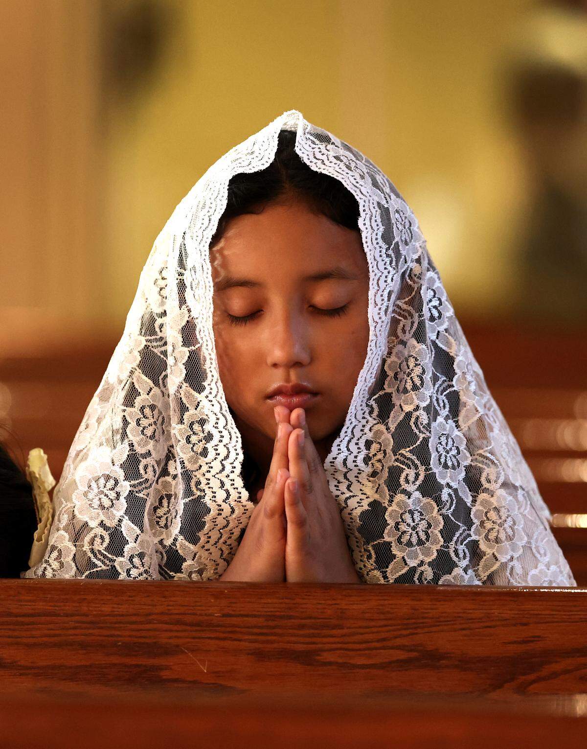 Amy Zacarias, age 9, prays during a Mass for Pope Francis on Wednesday, April 23, 2025, at Saint Mark Catholic Church in Huntersville, NC.